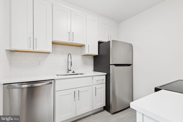 5817 Jamestown Rd, Hyattsville, MD 20782 - kitchen featuring appliances with stainless steel finishes, a sink, light countertops, white cabinets, and backsplash