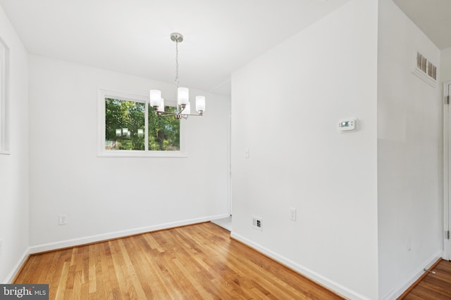 5817 Jamestown Rd, Hyattsville, MD 20782 - empty room with a chandelier, wood finished floors, and baseboards
