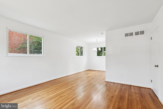 5817 Jamestown Rd, Hyattsville, MD 20782 - empty room featuring a chandelier, light wood finished floors, and baseboards