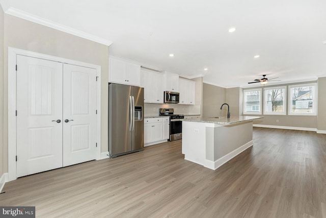 kitchen with appliances with stainless steel finishes, crown molding, light wood-style floors, white cabinets, and baseboards