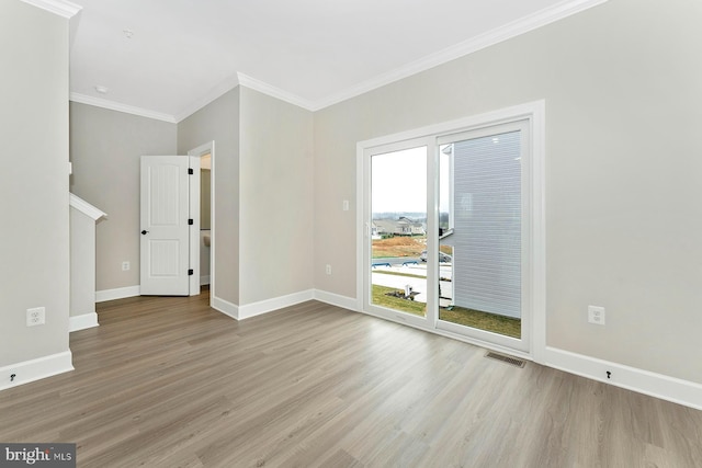 unfurnished living room with wood finished floors, ornamental molding, and baseboards