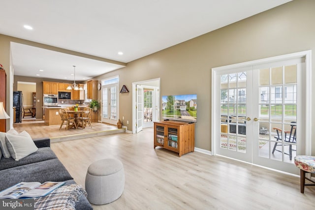 12649 Victory Lakes Loop, Bristow, VA 20136 - living room featuring french doors, light wood finished floors, a chandelier, and recessed lighting