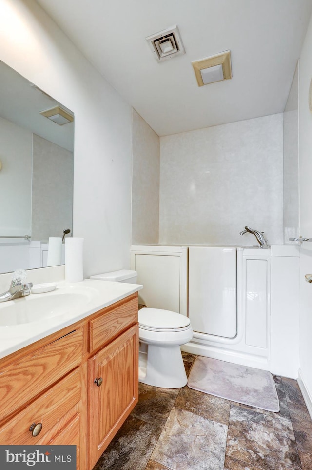 137 S Ronks Rd, Ronks, PA 17572 - bathroom with stone finish flooring, vanity, toilet, and a tub to relax in