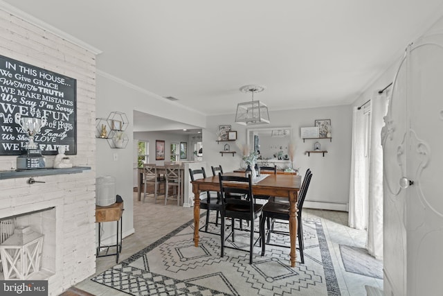 dining space with crown molding, baseboards, and baseboard heating