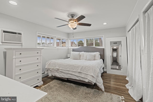 bedroom with an AC wall unit, recessed lighting, dark wood-style flooring, ceiling fan, and a baseboard heating unit
