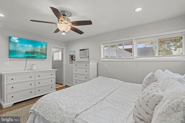 bedroom featuring wood finished floors, a baseboard heating unit, recessed lighting, ceiling fan, and a wall mounted AC