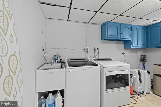 washroom with cabinet space, washer and dryer, and light wood-style floors