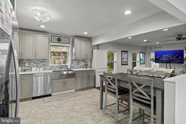 kitchen with a sink, appliances with stainless steel finishes, gray cabinetry, decorative backsplash, and recessed lighting