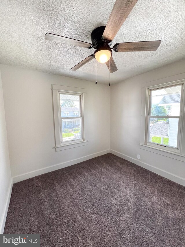 502 S Wayne St, Lewistown, PA 17044 - empty room featuring a textured ceiling, dark colored carpet, ceiling fan, and baseboards