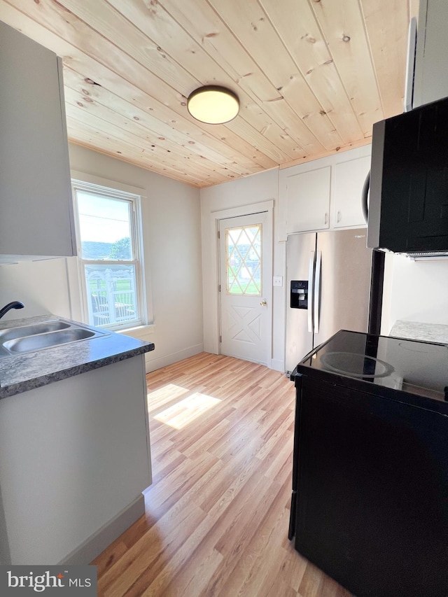 502 S Wayne St, Lewistown, PA 17044 - kitchen with a sink, wood ceiling, light wood finished floors, black microwave, and white cabinets