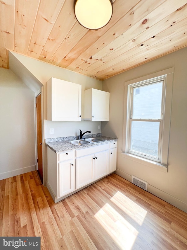 502 S Wayne St, Lewistown, PA 17044 - kitchen with a sink, white cabinetry, light wood-style flooring, wood ceiling, and baseboards
