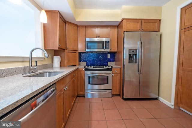 8803 Duveen Dr, Glenside, PA 19038 - kitchen featuring stainless steel appliances, a sink, brown cabinetry, tasteful backsplash, and light tile patterned flooring