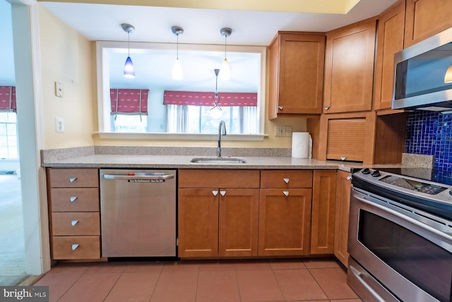 8803 Duveen Dr, Glenside, PA 19038 - kitchen featuring stainless steel appliances, a sink, brown cabinetry, light tile patterned flooring, and light stone countertops