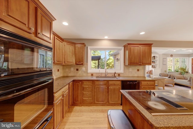 102 Windsong Dr, Doylestown, PA 18901 - kitchen featuring a sink, black appliances, light wood finished floors, open floor plan, and decorative backsplash