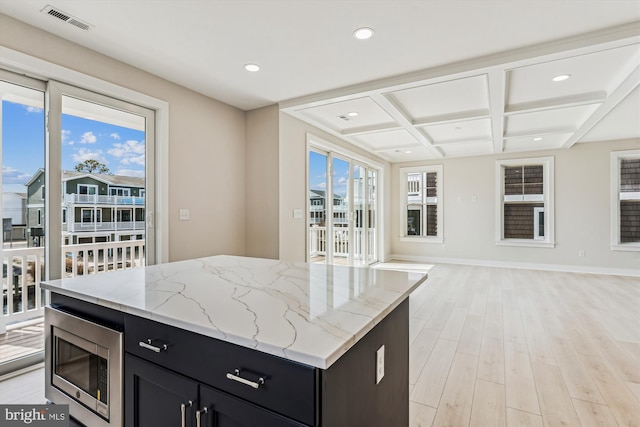 57 Bayside Dr, Fenwick Island, DE 19944 - kitchen featuring stainless steel microwave, open floor plan, coffered ceiling, dark cabinets, and light stone counters