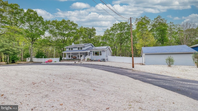 411 Spencer, Galloway, NJ 08205 - view of front of house with covered porch, roof mounted solar panels, fence, and view of scattered trees