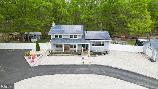411 Spencer, Galloway, NJ 08205 - view of front of property with solar panels, a porch, a chimney, a fenced backyard, and a view of trees