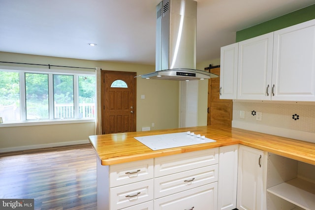 175 Mountain Heights Rd, Front Royal, VA 22630 - kitchen with white electric cooktop, island exhaust hood, wooden counters, a peninsula, and backsplash