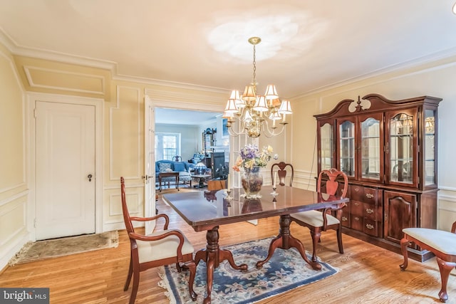 6427 Woodcrest Ave, Philadelphia, PA 19151 - dining area featuring a decorative wall, a chandelier, light wood-style floors, and crown molding