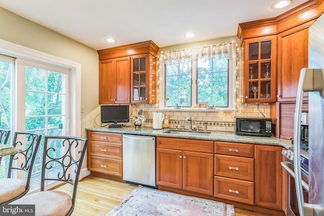 6427 Woodcrest Ave, Philadelphia, PA 19151 - kitchen featuring appliances with stainless steel finishes, a sink, brown cabinets, light stone countertops, and recessed lighting