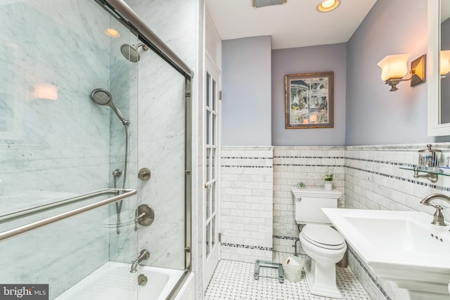 6427 Woodcrest Ave, Philadelphia, PA 19151 - full bath featuring tile patterned floors, a sink, toilet, tile walls, and a wainscoted wall