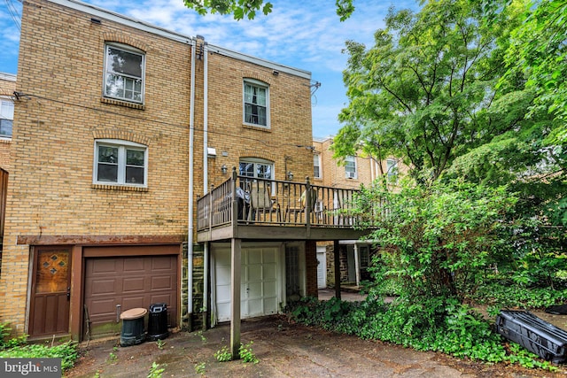 6427 Woodcrest Ave, Philadelphia, PA 19151 - back of house with brick siding, a garage, driveway, and a deck