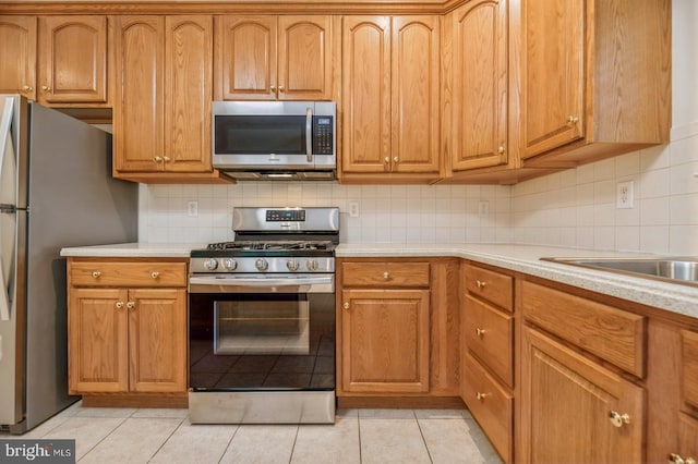 1 Grande Blvd, West Windsor, NJ 08550 - kitchen featuring appliances with stainless steel finishes, backsplash, light countertops, and light tile patterned flooring