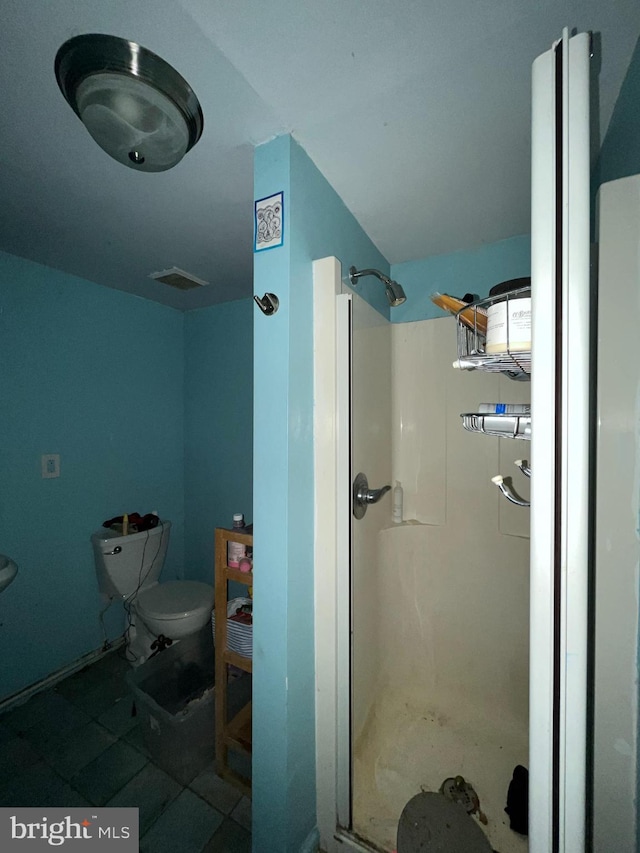 bathroom with a shower stall and toilet