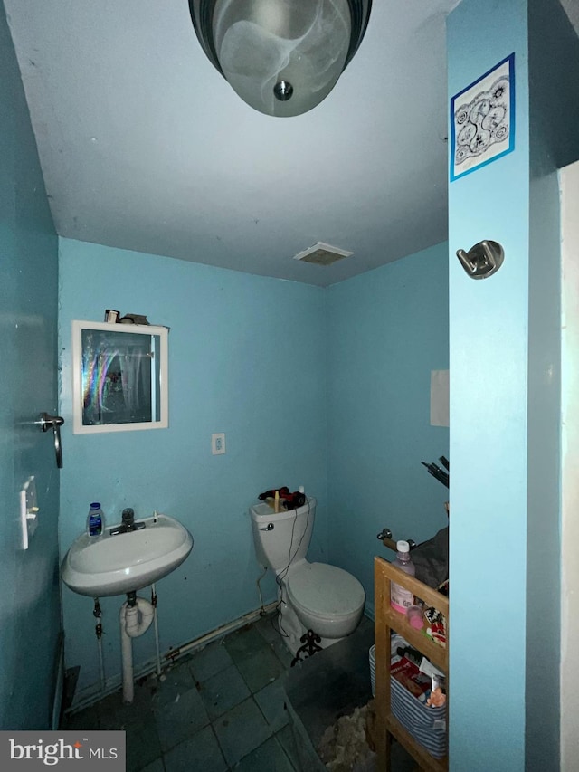 half bath featuring toilet and a sink
