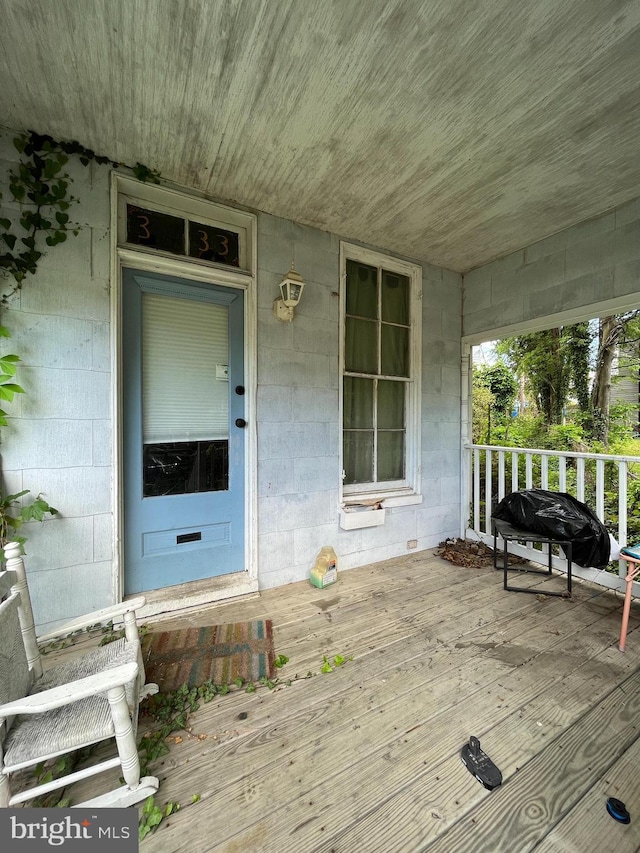 doorway to property featuring concrete block siding and covered porch