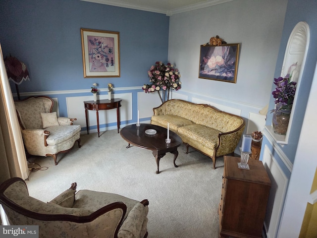 living area with carpet flooring, ornamental molding, and wainscoting