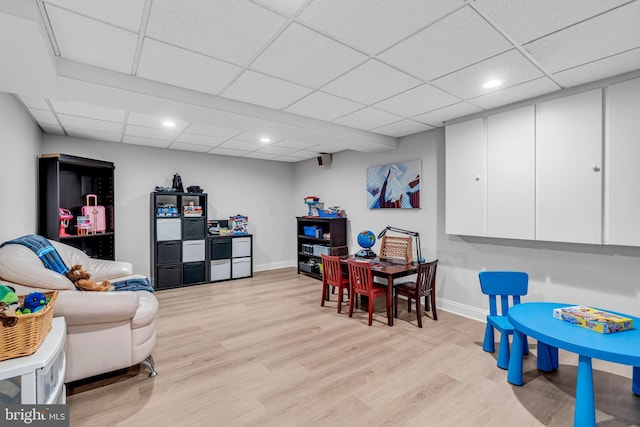 rec room with light wood-type flooring, a drop ceiling, recessed lighting, and baseboards