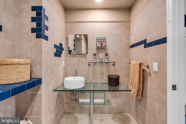 bathroom with a sink and tile walls