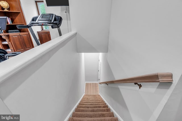 stairway featuring carpet and baseboards