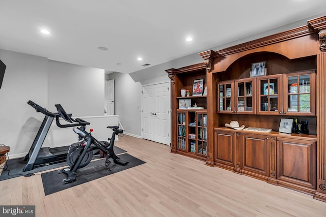 exercise room featuring light wood finished floors, baseboards, and recessed lighting