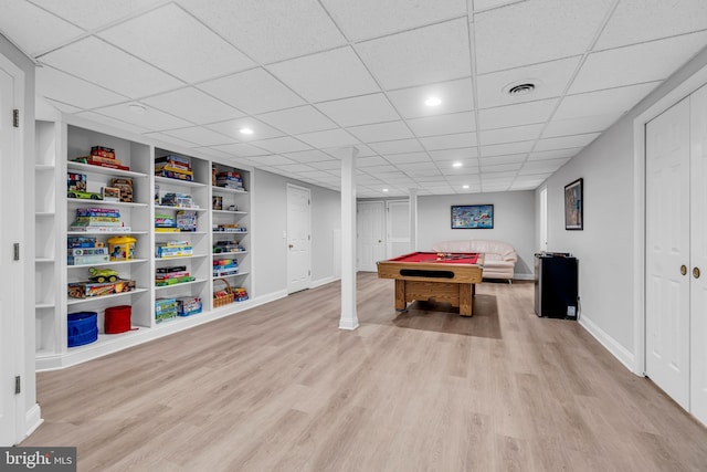 recreation room with light wood-style flooring, billiards table, built in features, baseboards, and a drop ceiling