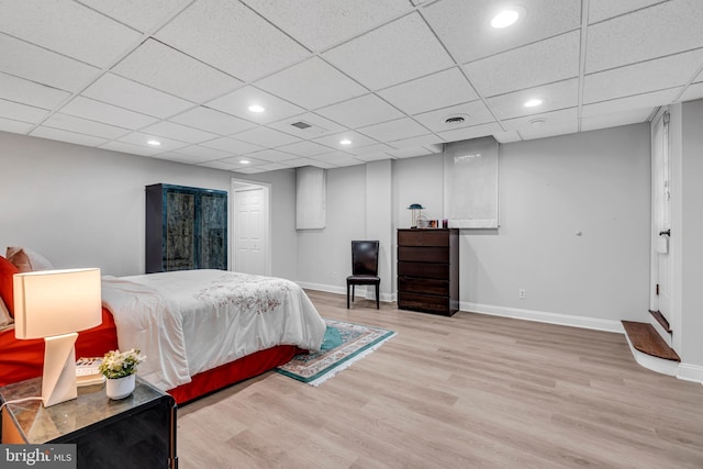 bedroom with wood finished floors, baseboards, recessed lighting, and a drop ceiling