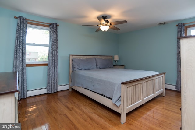 303 N Elm Ave, Newtown, PA 18940 - bedroom featuring baseboard heating, wood finished floors, and a ceiling fan