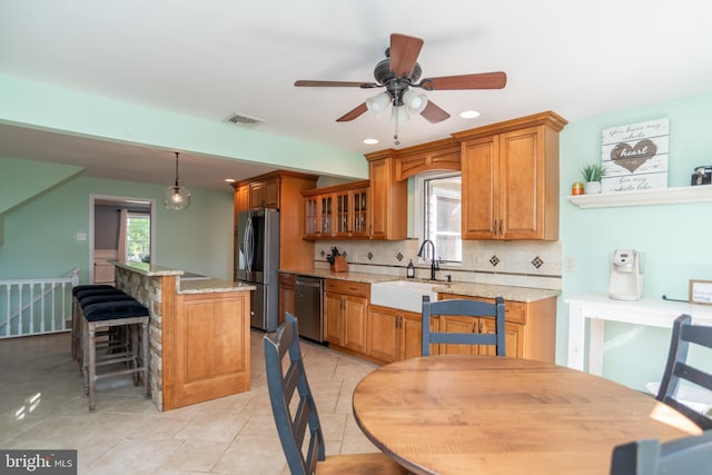 303 N Elm Ave, Newtown, PA 18940 - kitchen featuring stainless steel appliances, brown cabinets, backsplash, ceiling fan, and light tile patterned flooring