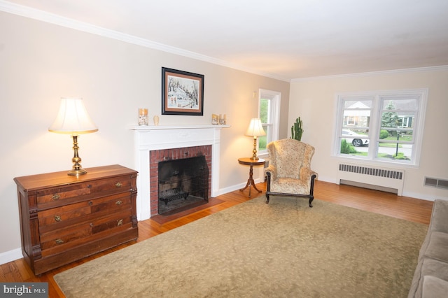 525 Croyden Rd, Cheltenham, PA 19012 - living area with radiator, wood finished floors, crown molding, a brick fireplace, and healthy amount of natural light