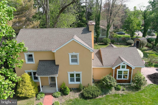 525 Croyden Rd, Cheltenham, PA 19012 - rear view of house featuring stucco siding, a chimney, roof with shingles, and fence