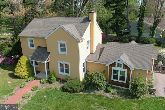 525 Croyden Rd, Cheltenham, PA 19012 - traditional home featuring a chimney, stucco siding, a front lawn, and roof with shingles