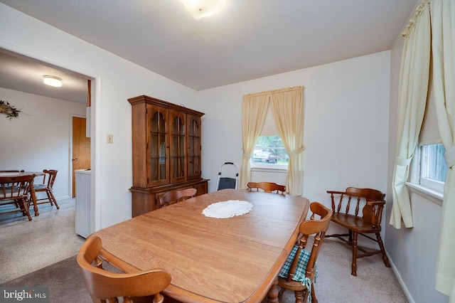 dining area featuring light colored carpet and baseboards