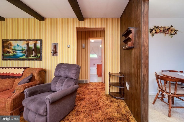 sitting room with beam ceiling, carpet, and baseboards