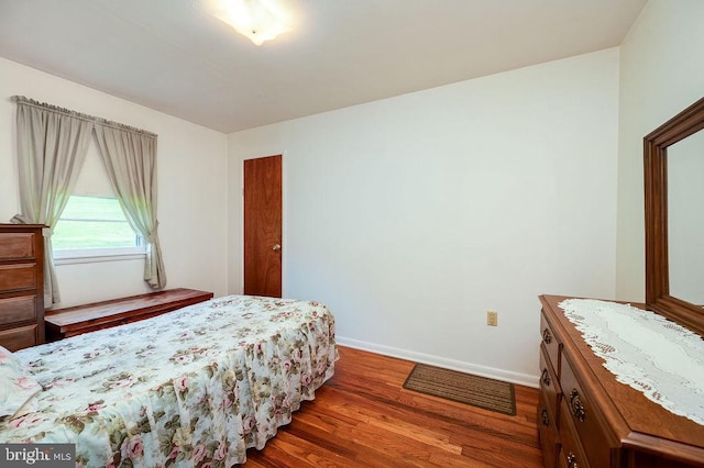 bedroom featuring wood finished floors and baseboards