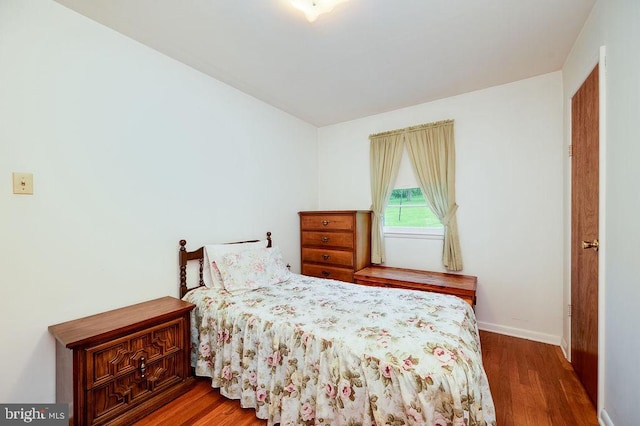 bedroom with wood finished floors and baseboards