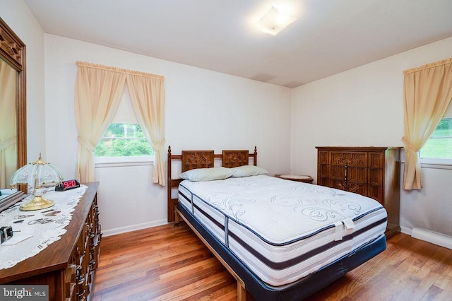 bedroom with light wood finished floors and baseboards