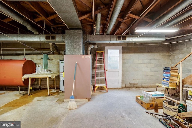unfinished below grade area featuring oil tank and electric water heater