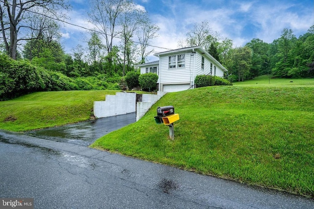 view of home's exterior featuring a garage, driveway, and a yard