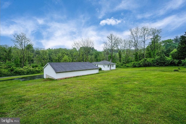 view of green lawn with a wooded view